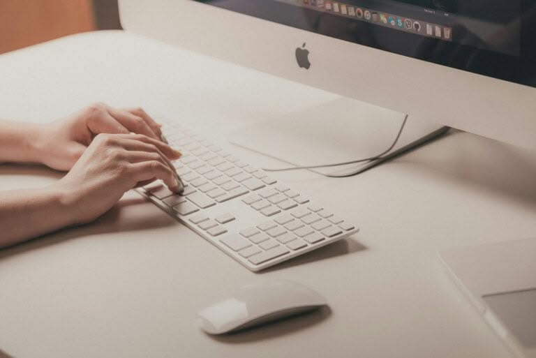 What Is Content Decay How to Fix Content Decay Issues | Person Typing on Computer | Cahaba Digital
